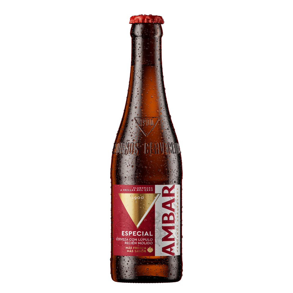 Botella de cerveza Ambar Especial fría con gotas de agua en el cristal marrón y chapa metálica roja. Destaca su etiqueta central en tonos rojo, dorado y blanco con el logotipo de Ambar, la palabra "ESPECIAL" y el grabado en relieve en el vidrio con el año "1900" y la frase "Pequeños Cerveceros".