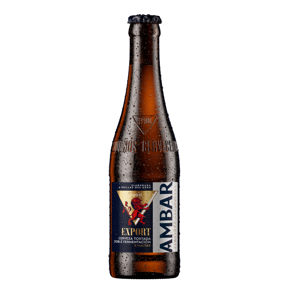 Botella de cerveza Ambar Export fría con gotas de agua sobre el cristal marrón, chapa metálica negra y grabado en relieve con "1900" y "Pequeños Cerveceros". La etiqueta frontal combina tonos azul marino, dorado y blanco, destacando la ilustración de un león rampante en color rojo, la palabra "EXPORT" y la descripción "Cerveza tostada doble fermentación - 3 maltas".