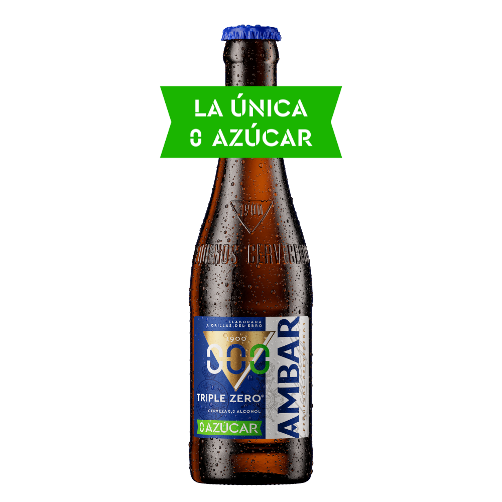 Botella de cerveza Ambar Triple Zero fría sobre cristal marrón con gotas de agua y chapa azul metálica. Destaca una cinta promocional verde superpuesta en el cuello de la botella con el texto en blanco "LA ÚNICA 0 AZÚCAR". La etiqueta frontal combina tonos azul, blanco y verde con el distintivo logo "000", las palabras "TRIPLE ZERO" y el distintivo inferior "0 AZÚCAR". El vidrio incluye grabado en relieve "1900" y "Pequeños Cerveceros".