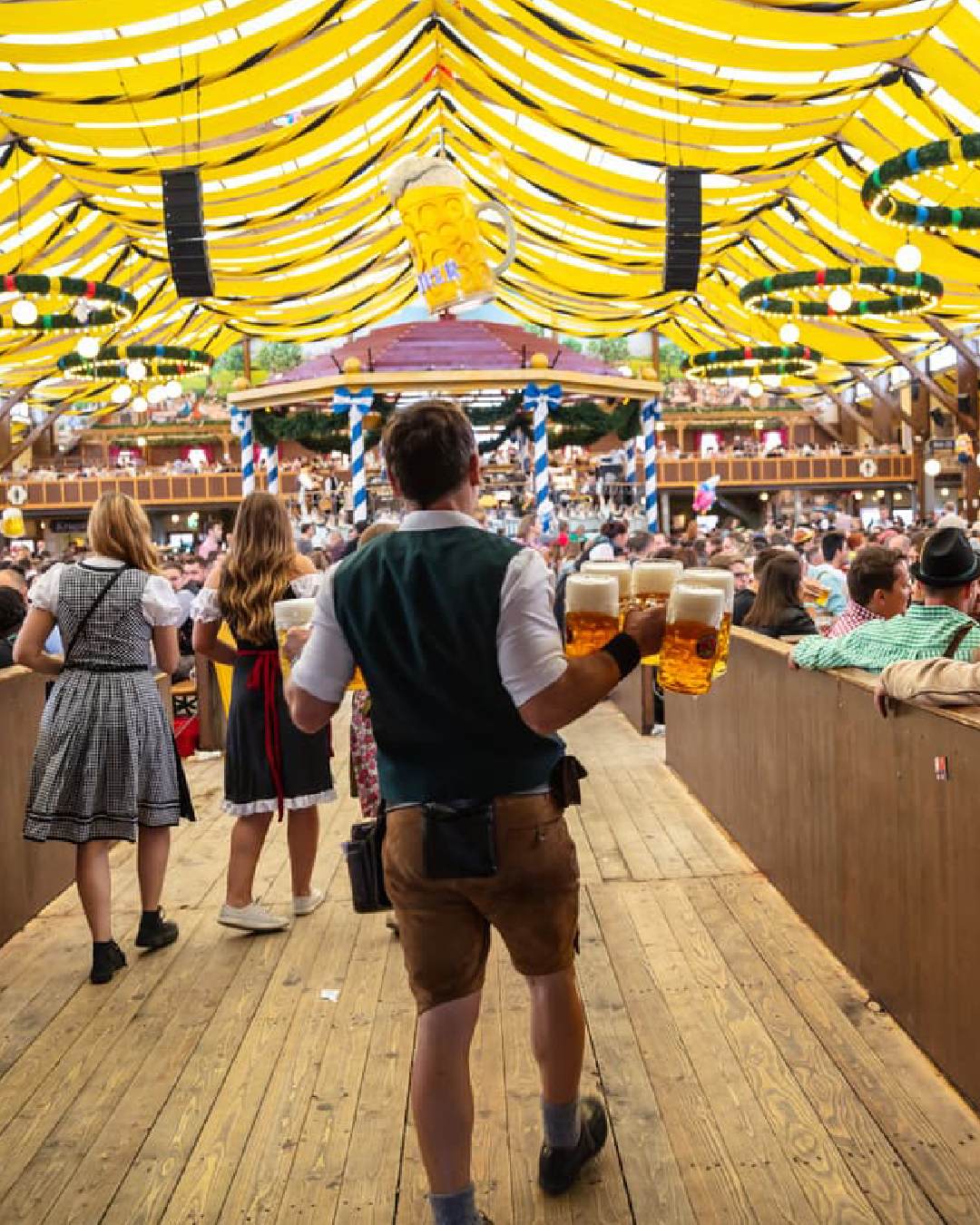Una carpa del Oktoberfst en Munich en la actualidad llena de gente celebrando la festividad.